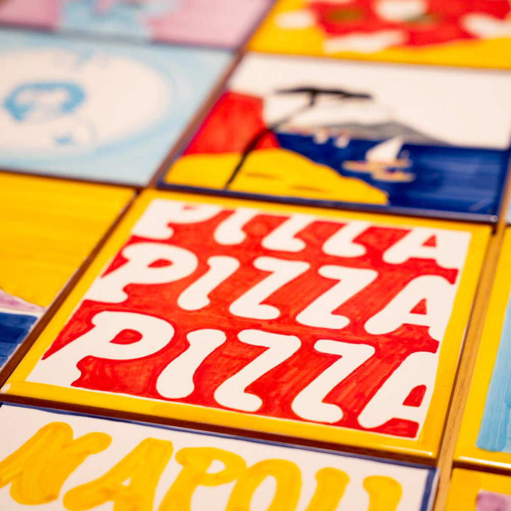 Maiolica artigianale dipinta a mano con paesaggio del Golfo di Napoli, Vesuvio fumante, mare blu intenso, barche colorate e scogliera rossa su terracotta di pasta rossa smaltata.