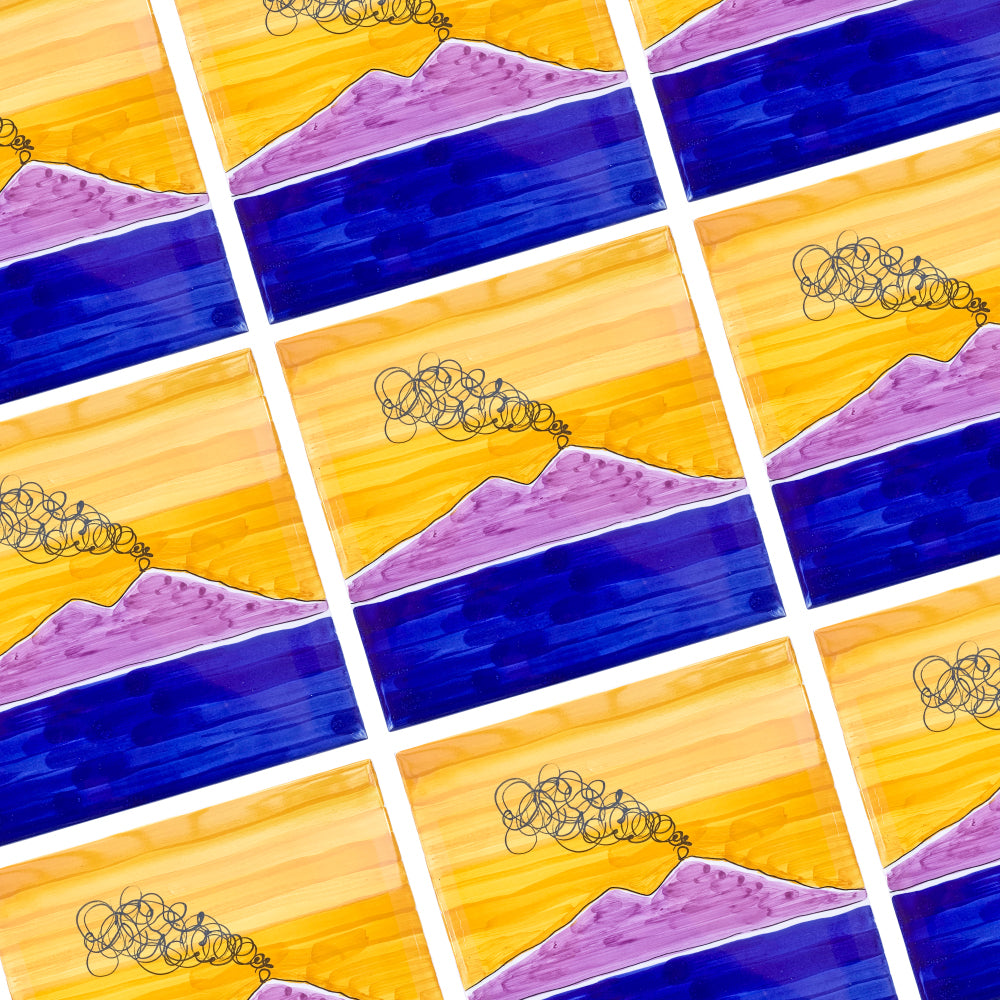 Maiolica artigianale Pil Pil raffigurante il Vesuvio stilizzato in viola con fumo nero su sfondo di cielo arancione e mare blu profondo, dipinta a mano con stile contemporaneo.