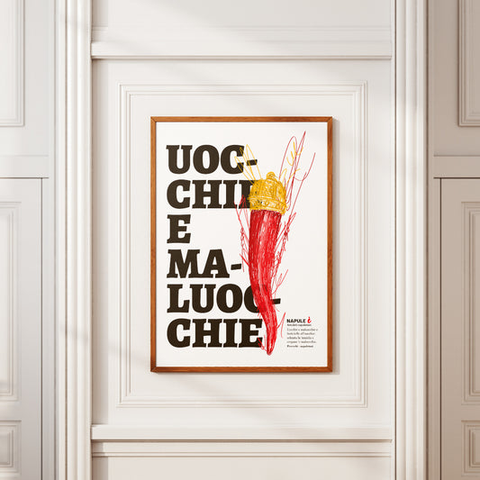 Il poster raffigura un grande corno portafortuna napoletano di colore rosso, sormontato da una corona dorata, disegnato con tratti grafici stilizzati. Sullo sfondo, in caratteri neri e grandi, appare la scritta dialettale Uocchie e Maluocchie. In basso a destra e presente un testo esplicativo che richiama un proverbio napoletano legato alla tradizione degli amuleti contro il malocchio