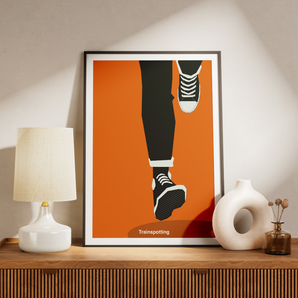Poster minimalista ispirato a Trainspotting con illustrazione delle gambe in corsa che richiama la celebre scena iniziale del film cult di Danny Boyle. Stampa artistica moderna in stile grafico ideale per gli amanti del cinema e del design contemporaneo.