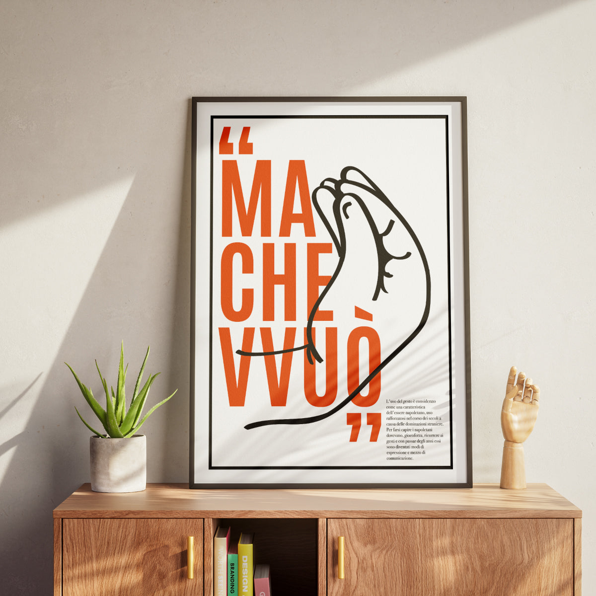Poster tipografico minimalista con frase Ma che vvuo in rosso su sfondo grigio, accompagnato da illustrazione stilizzata del gesto napoletano con dita unite verso l’alto.