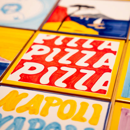 Maiolica artigianale Pil Pil in terracotta di pasta rossa smaltata, con decorazione grafica rossa e bianca con la scritta PIZZA ripetuta, ispirata alla tradizione napoletana.