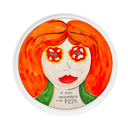 Piatto pizza artigianale in ceramica dipinto a mano con volto femminile dai capelli rossi e occhi a forma di pizza Margherita Sul piatto e presente la scritta Mi sono innamorata di una Pizza Decorazione originale in stile pop art ideale per arredare cucina pizzeria o come regalo per gli amanti della pizza