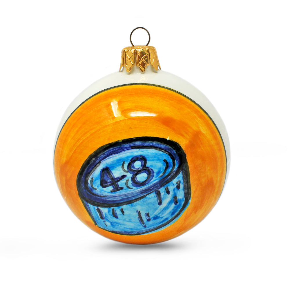 Palla di Natale artigianale Pil Pil dipinta a mano, bianca con decorazione arancione e illustrazione azzurra del bussolotto della tombola napoletana con numero 48, simbolo della Smorfia.