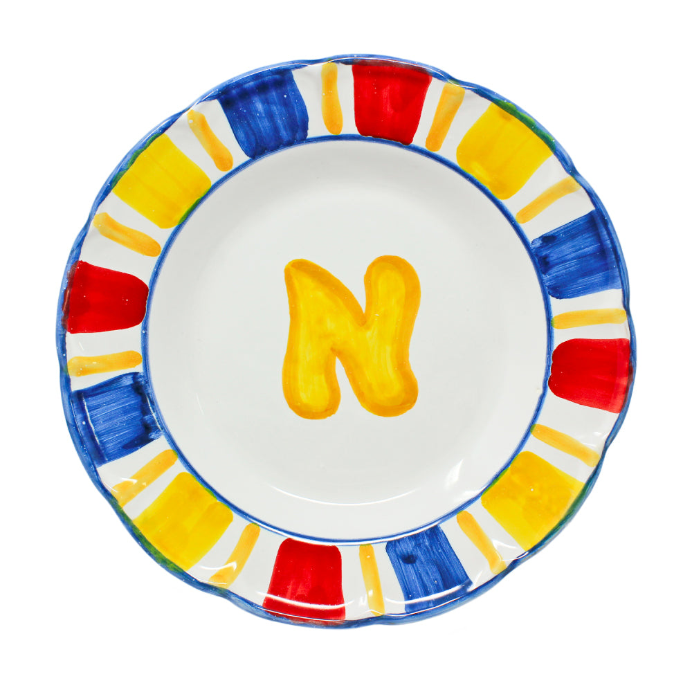 Piatto fondo Napoli in ceramica artigianale dipinta a mano, con lettera N gialla al centro e bordo decorato in rosso, blu e giallo. Pil Pil Design Partenopeo.