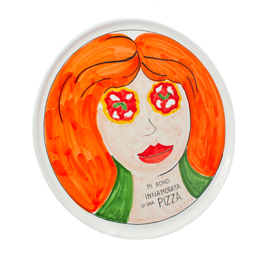 Piatto pizza artigianale in ceramica dipinto a mano con volto femminile dai capelli rossi e occhi a forma di pizza Margherita Sul piatto e presente la scritta Mi sono innamorata di una Pizza Decorazione originale in stile pop art ideale per arredare cucina pizzeria o come regalo per gli amanti della pizza