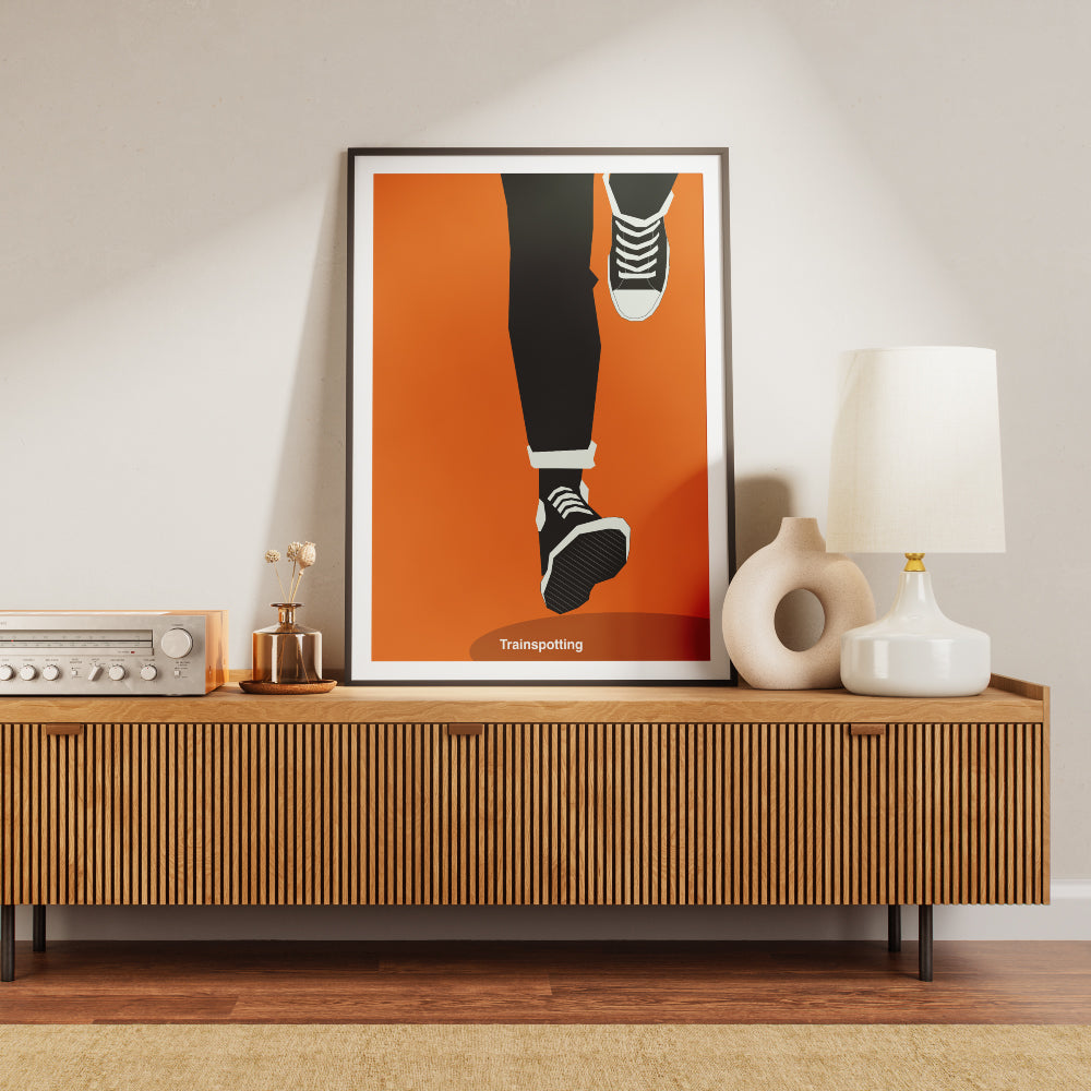 Poster minimalista ispirato a Trainspotting con illustrazione delle gambe in corsa che richiama la celebre scena iniziale del film cult di Danny Boyle. Stampa artistica moderna in stile grafico ideale per gli amanti del cinema e del design contemporaneo.