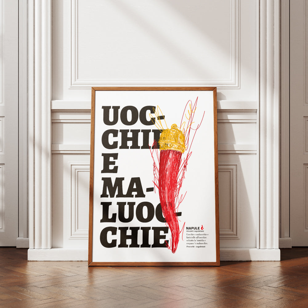 Il poster raffigura un grande corno portafortuna napoletano di colore rosso, sormontato da una corona dorata, disegnato con tratti grafici stilizzati. Sullo sfondo, in caratteri neri e grandi, appare la scritta dialettale Uocchie e Maluocchie. In basso a destra e presente un testo esplicativo che richiama un proverbio napoletano legato alla tradizione degli amuleti contro il malocchio